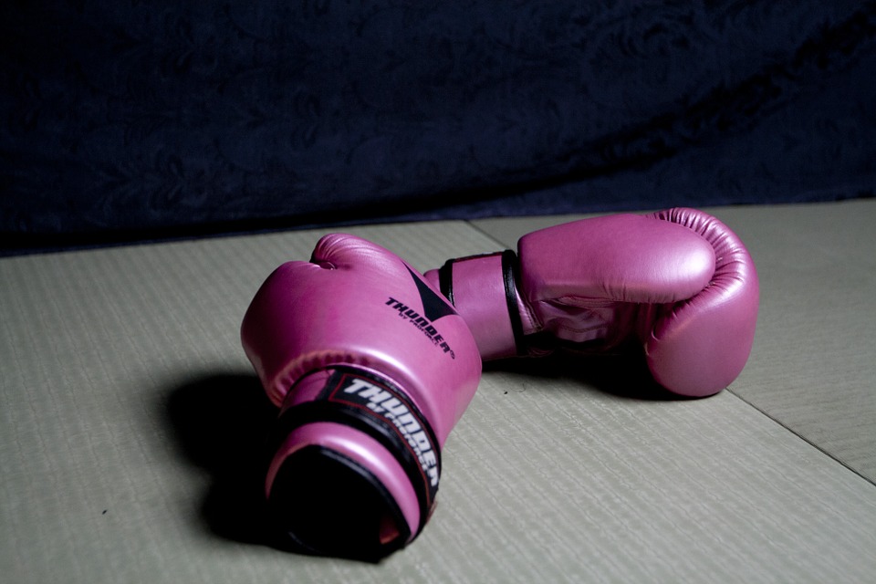 A pair of boxing gloves sitting on the floor, symbolizing fighting cancer