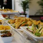 A table filled with food, including sandwiches and other small appetizers commonly served in funeral homes