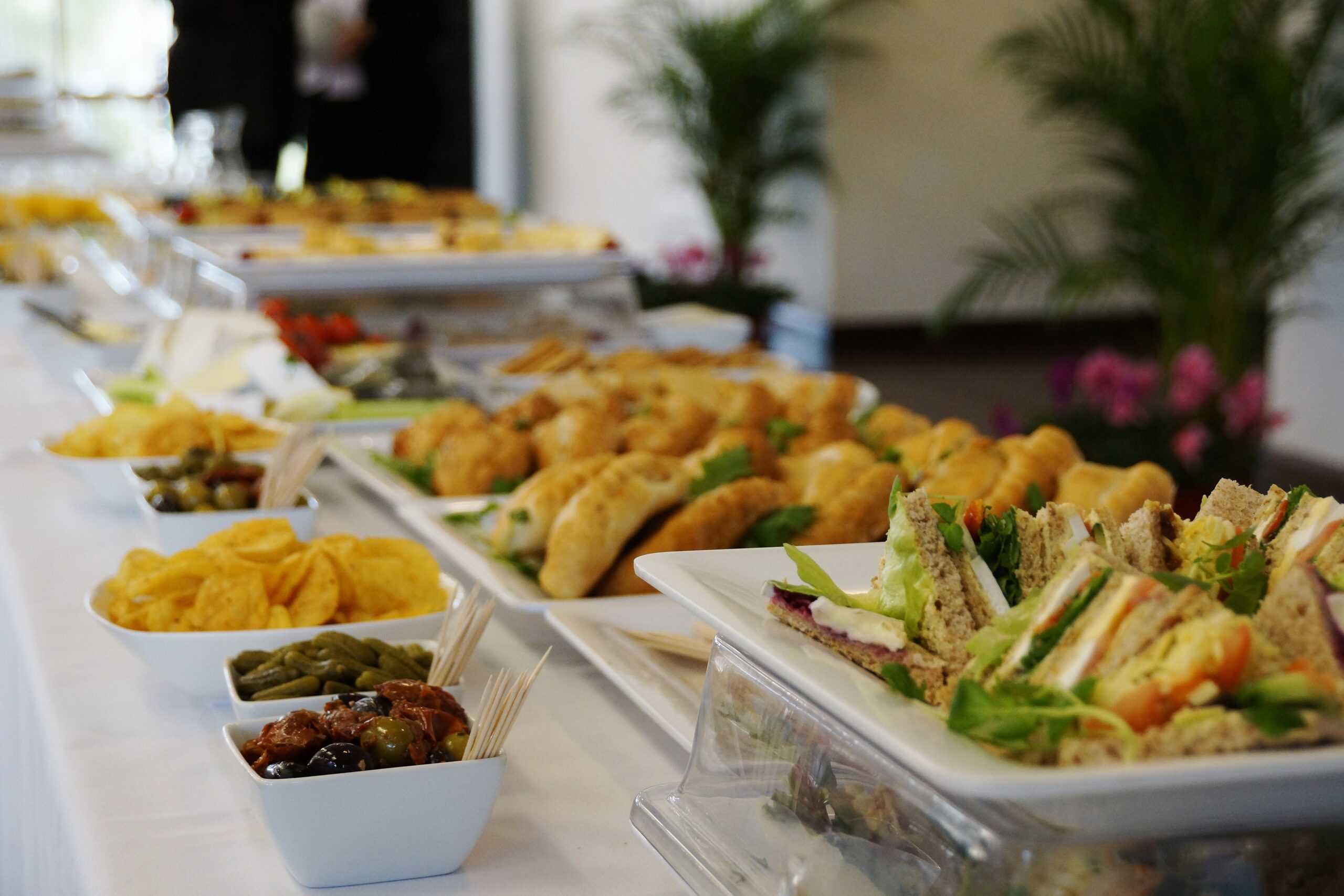 A table filled with food, including sandwiches and other small appetizers commonly served in funeral homes