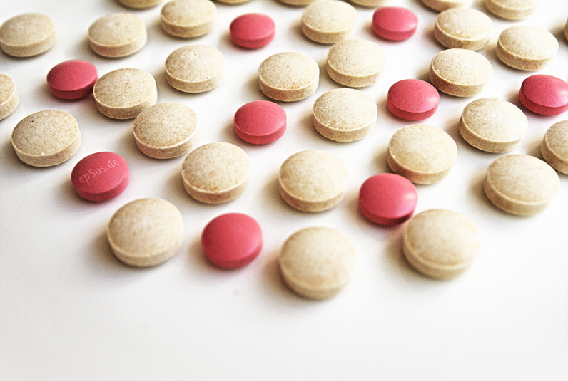 Alzheimer's drugs, with red and white pills sitting on a table