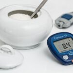 Bowl of sugar, blood sugar reader next to eachother symbolizing diabetes