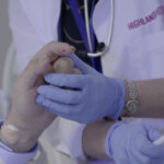 Doctor holds the hand of a patient near death