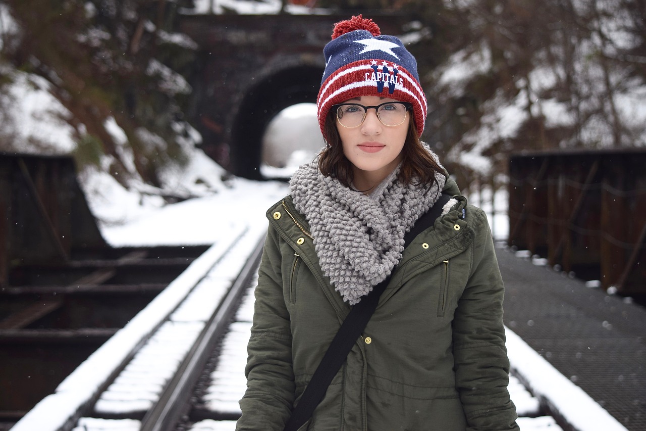 Teenager standing on railroad track with winter clothes symbolizing adolescence