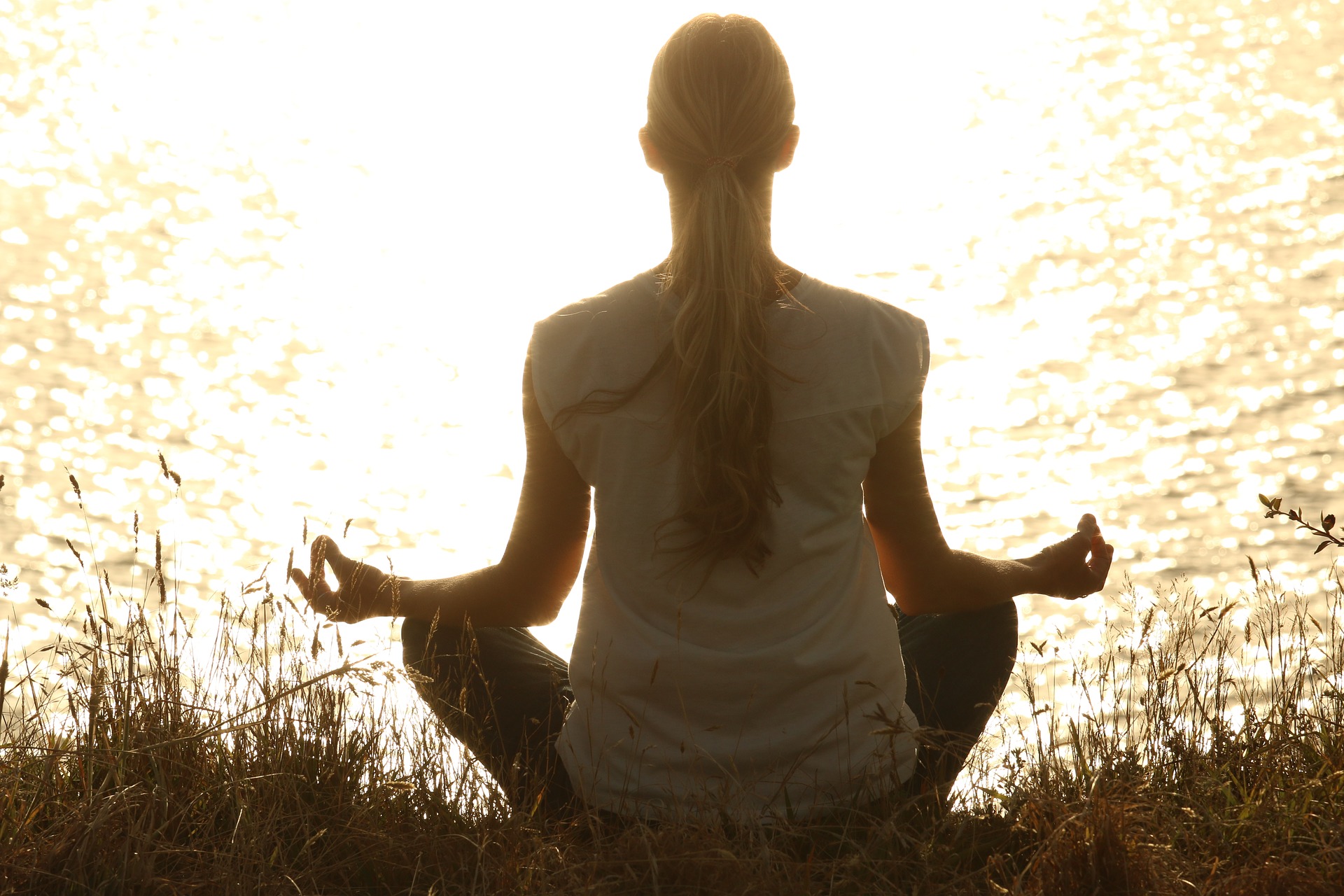 Woman meditating near lake symbolizing cancer therapy