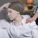 Female cancer patient in a head scarf looking stressed because of her illness.