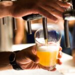 Draft beer being poured at a bar.