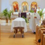 Priest sprinkle holy water at a Catholic funeral Mass
