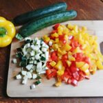 A chopping board with fresh vegetables sitting on top of it, which are part of a high-fiber diet