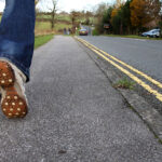 A person walking slowly along the side of the road; scientists have linked walking speed and heart disease
