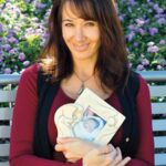 Dr. Cacciatore holding her daughter's photo has personally experienced traumatic grief