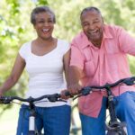 Elderly couple riding bicycles symbolizing exercise.