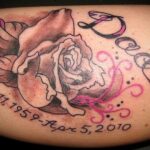 A photo of a cremation tattoo with a rose and dates