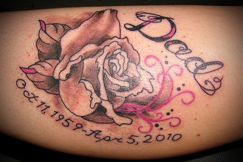 A photo of a cremation tattoo with a rose and dates