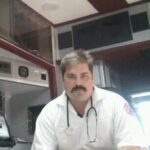 A photo of Dennis Kowalski sitting in an emergency vehicle