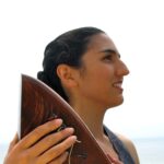 Portia Diwa holding her harp