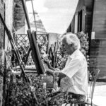 a black and white image of an elderly man painting as a part of active aging