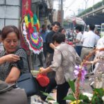 An image of a woman tying on a black respect band at a Chinese Funeral