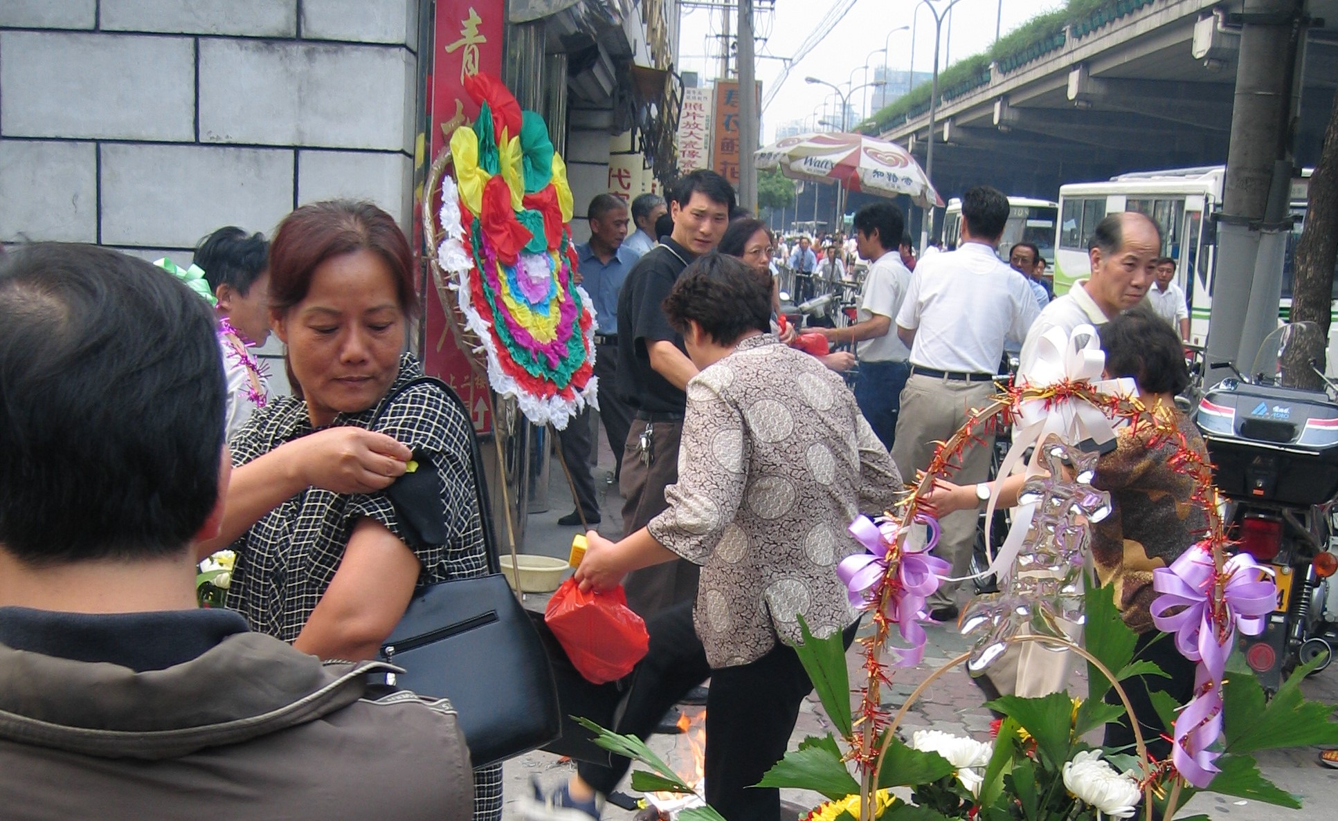 An image of a woman tying on a black respect band at a Chinese Funeral