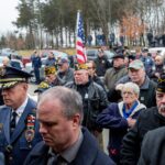 Crowd of veterans and public citizens standing attending Peter Turnpu's funeral.