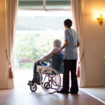 A man sits in a wheelchari in an assisted living facility