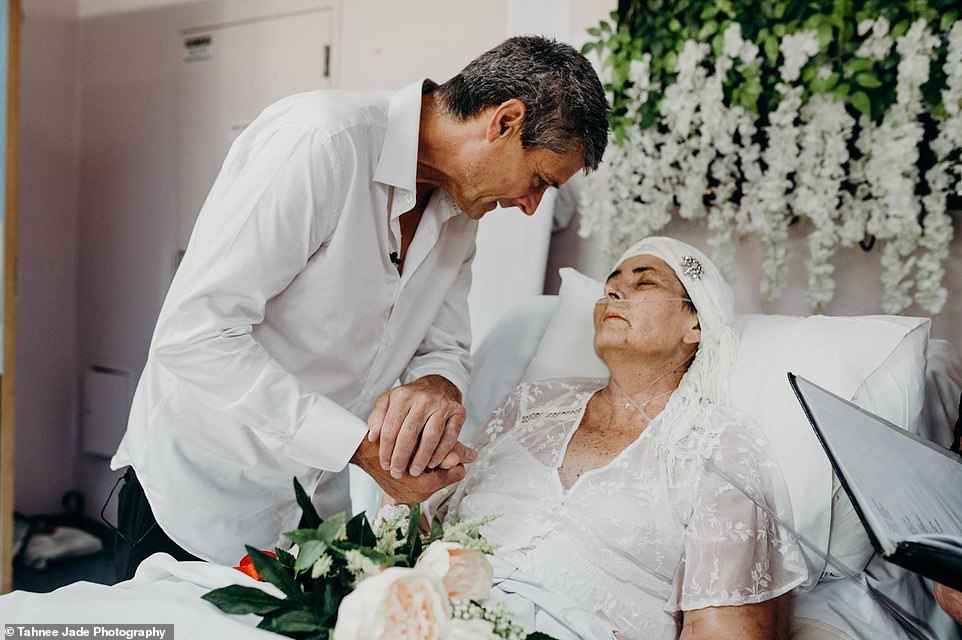 Colin and Tracey MacDonald holding hands during their wedding.