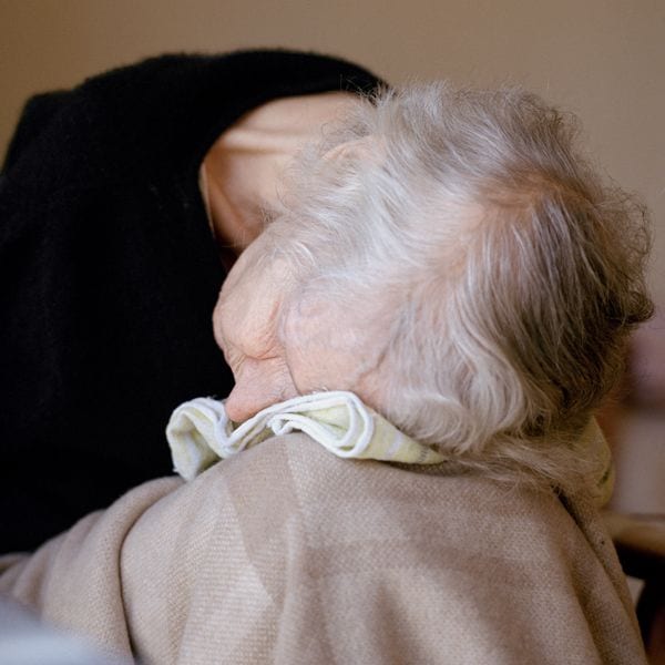An elderly woman slumped in a chair in hospice provider's care