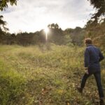 image of a man walking through a conservation burial ground indicating shifting attitudes about death
