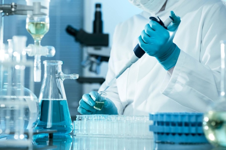 Scientific advancements have allowed scientists to reverse aging in cells; closeup of scientist wearing gloves injecting liquid into a test tube