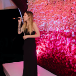 delivering a eulogy in front of wall of pink flowers