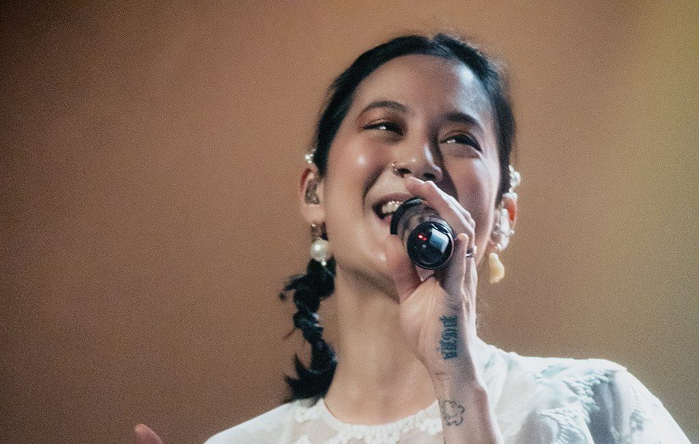 Michelle Zauner dressed in white, singing