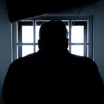 incarcerated individual in shadow
