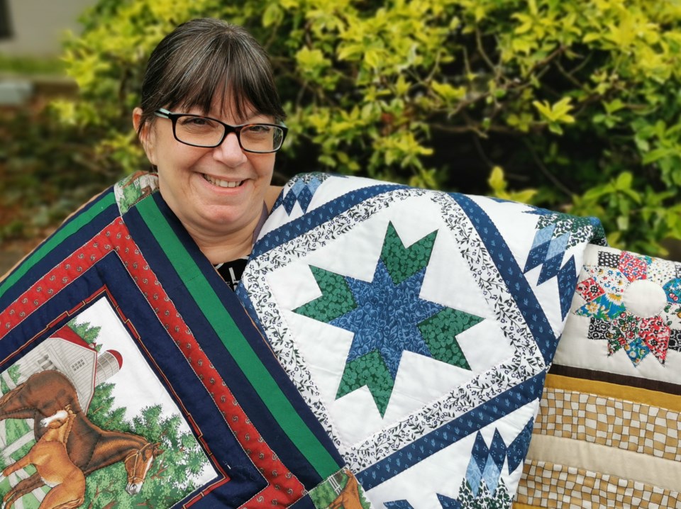 Nursing home employee holds dignity quilt to honor patients death