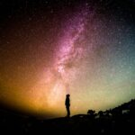 A person in silhouette against a starry night sky