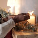 Woman lighting a candle on a mantle.