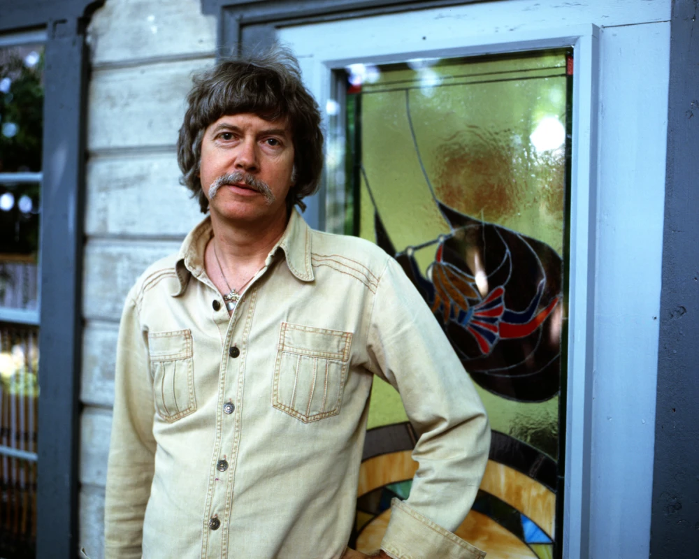 Tom Robbin standing in front of the door to his home.