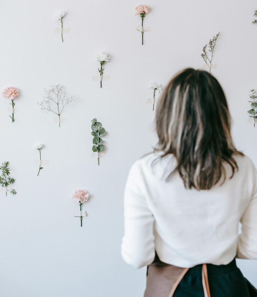 Fresh flower wall with a woman facing the wall.
