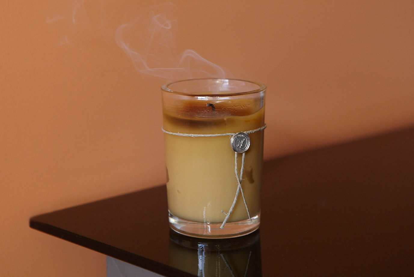 A blown out glass candle sits on the corner of a table symbolizing active dying