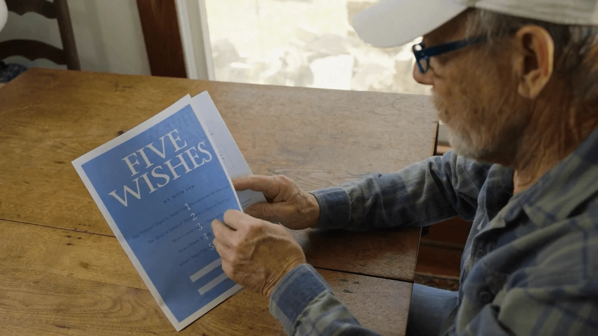 an older man is flipping through a five wishes advance directive