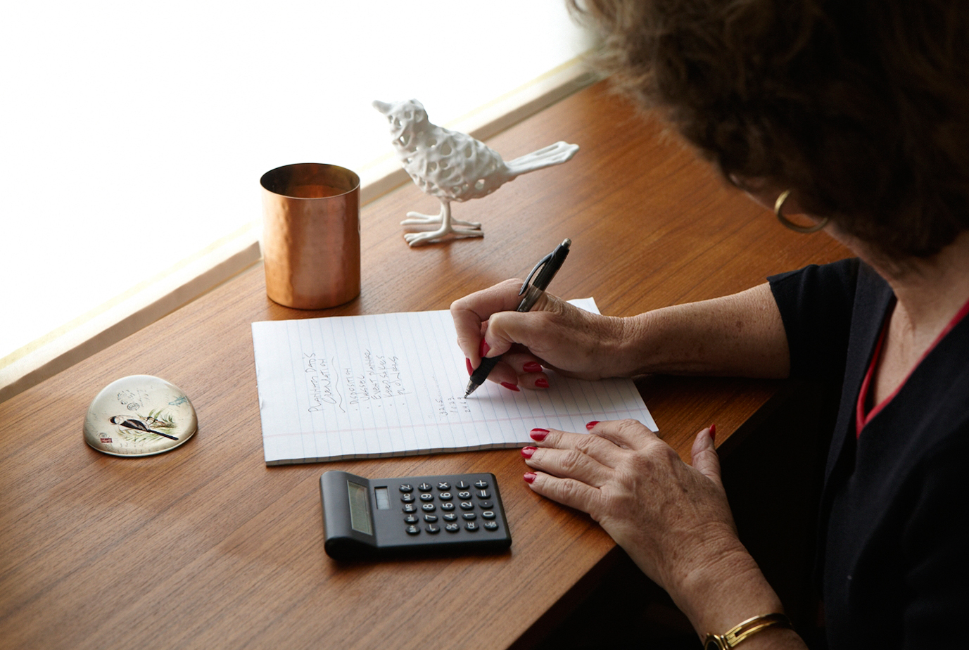 a woman at a desk pre-planning for funeral expenses