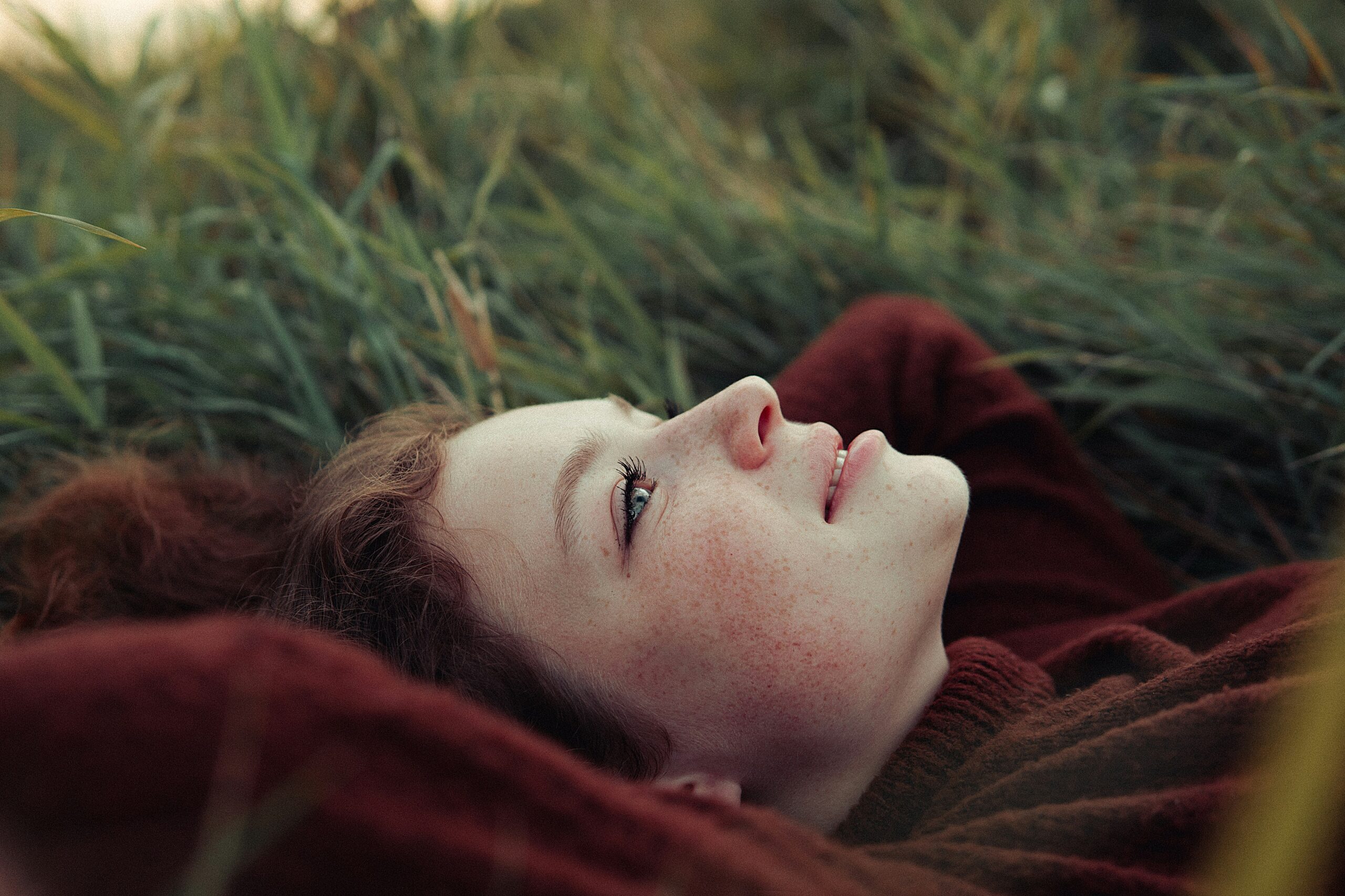 a woman laying in a field having accepted her mortality
