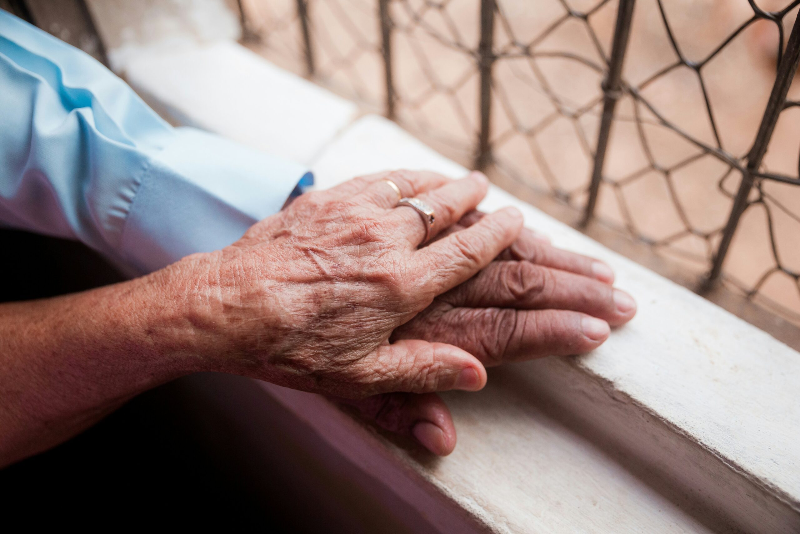 an older woman's hand holding an older man's hand showing comfort care at the end of life