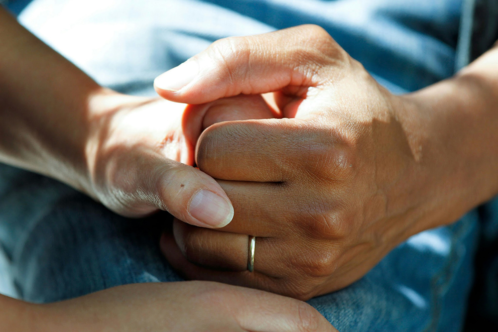 Two hands clasped together in an embrace.