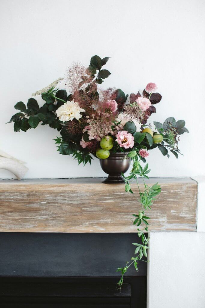 seasonal flower arrangement on a fireplace mantel