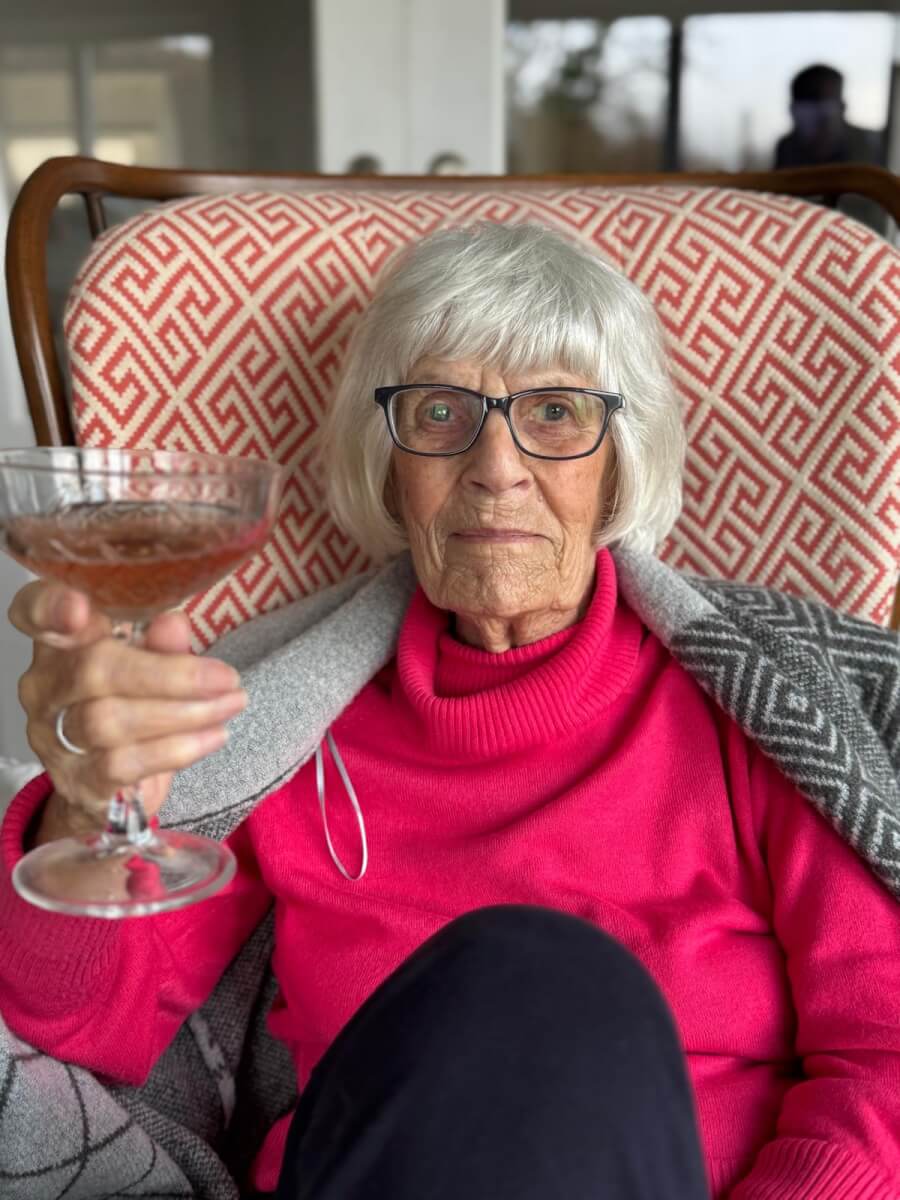 Woman whose husband organized a hospice fundraiser sitting in a lounge chair with a cocktail