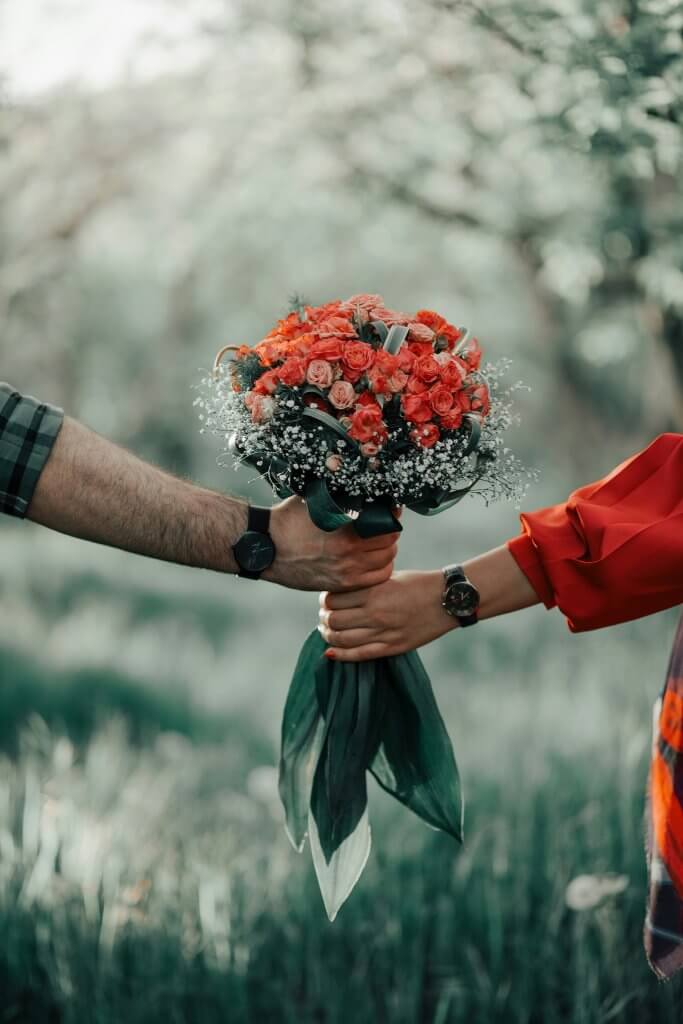 Someone gifting fresh floral bouquets to a guest at a celebration of life