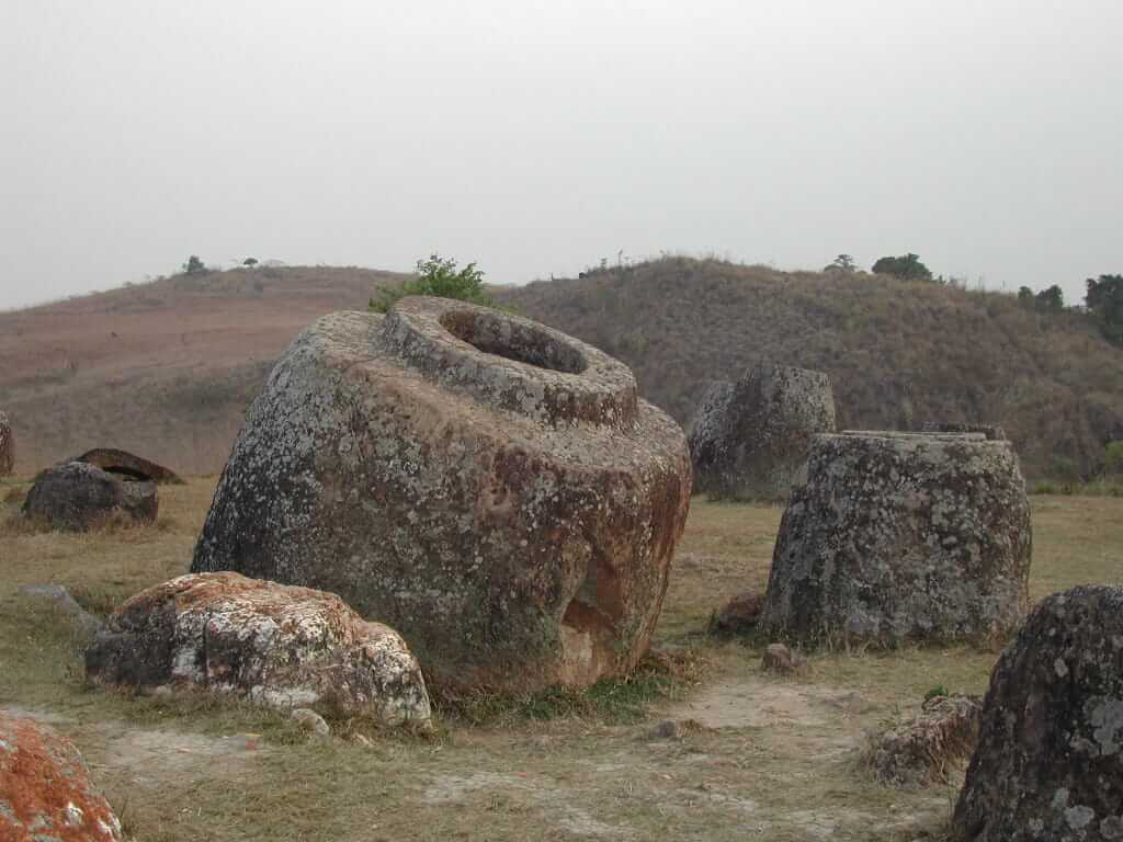 A massive stone jar sits amongst the ruins of other megaliths on the Plain of Jars. The latest discovery shows these jars were used to store human remains.