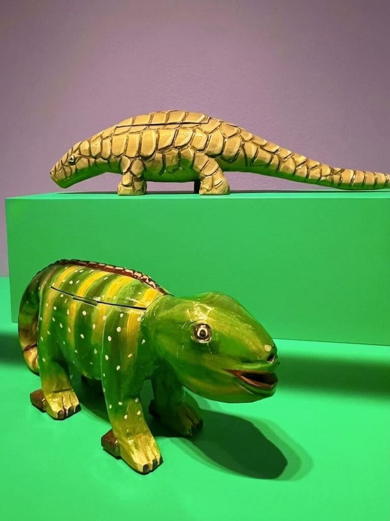 Handcrafted pangolin and chameleon sculptures from The Art Underground: Fantasy Coffins of Ghana exhibit at the Museum of International Folk Art in Santa Fe, New Mexico.