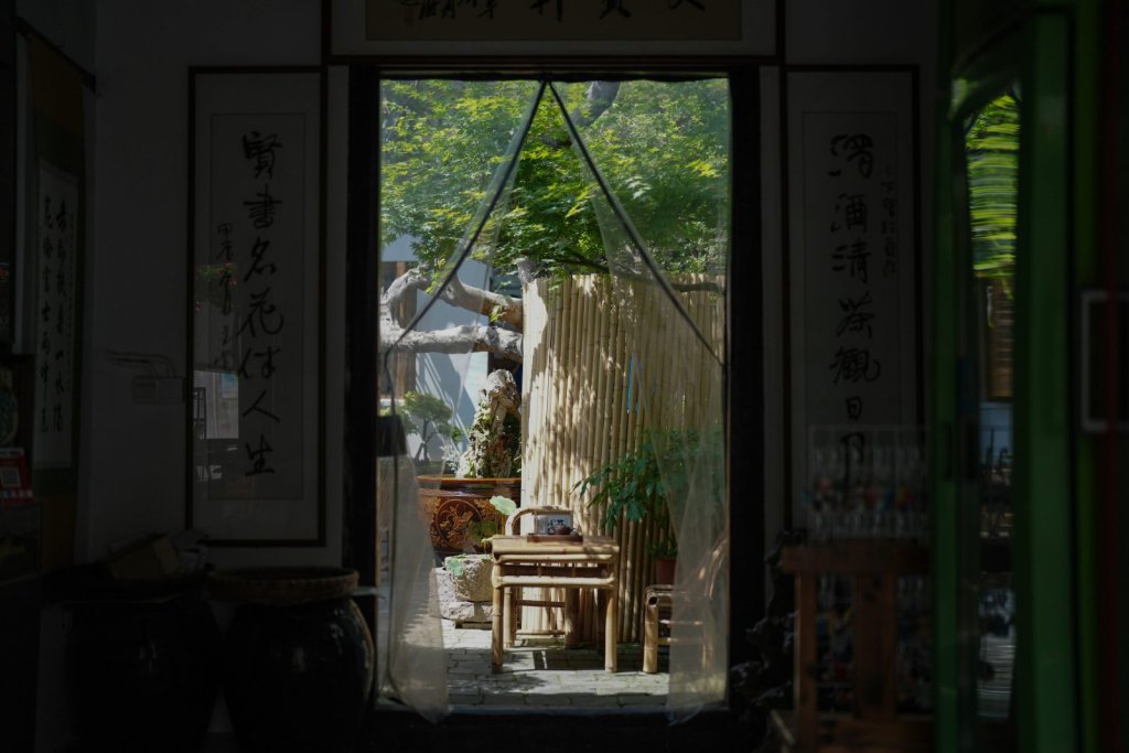 Empty bamboo chair and tea set in a quiet courtyard, evoking solitude and remembrance