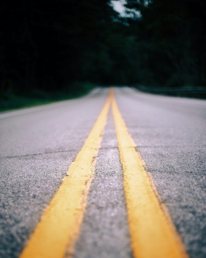 “Empty road with double yellow lines, representing the long road of healing after loss.”
